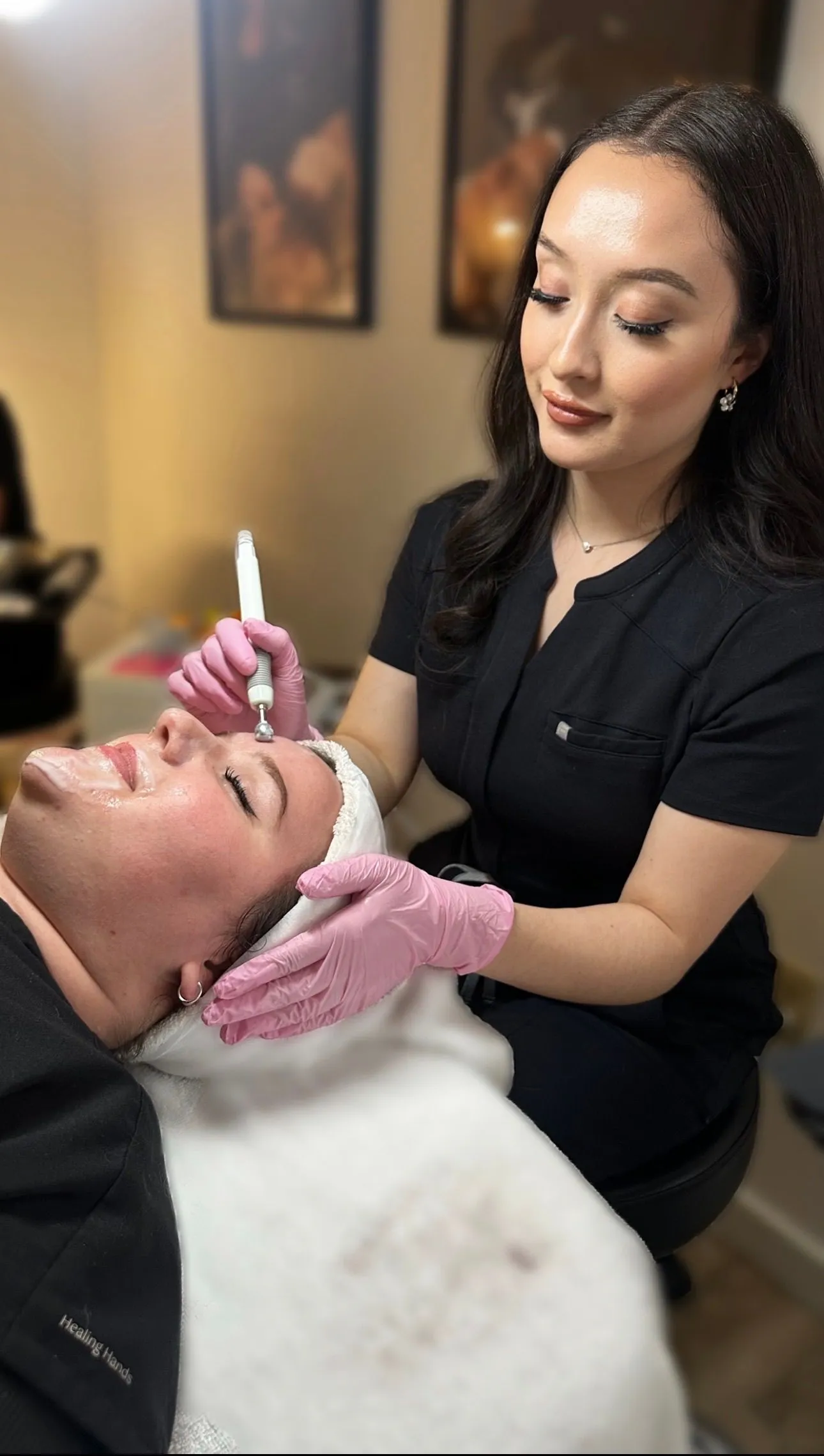 Practitioner uses a professional skincare device while caring for a client